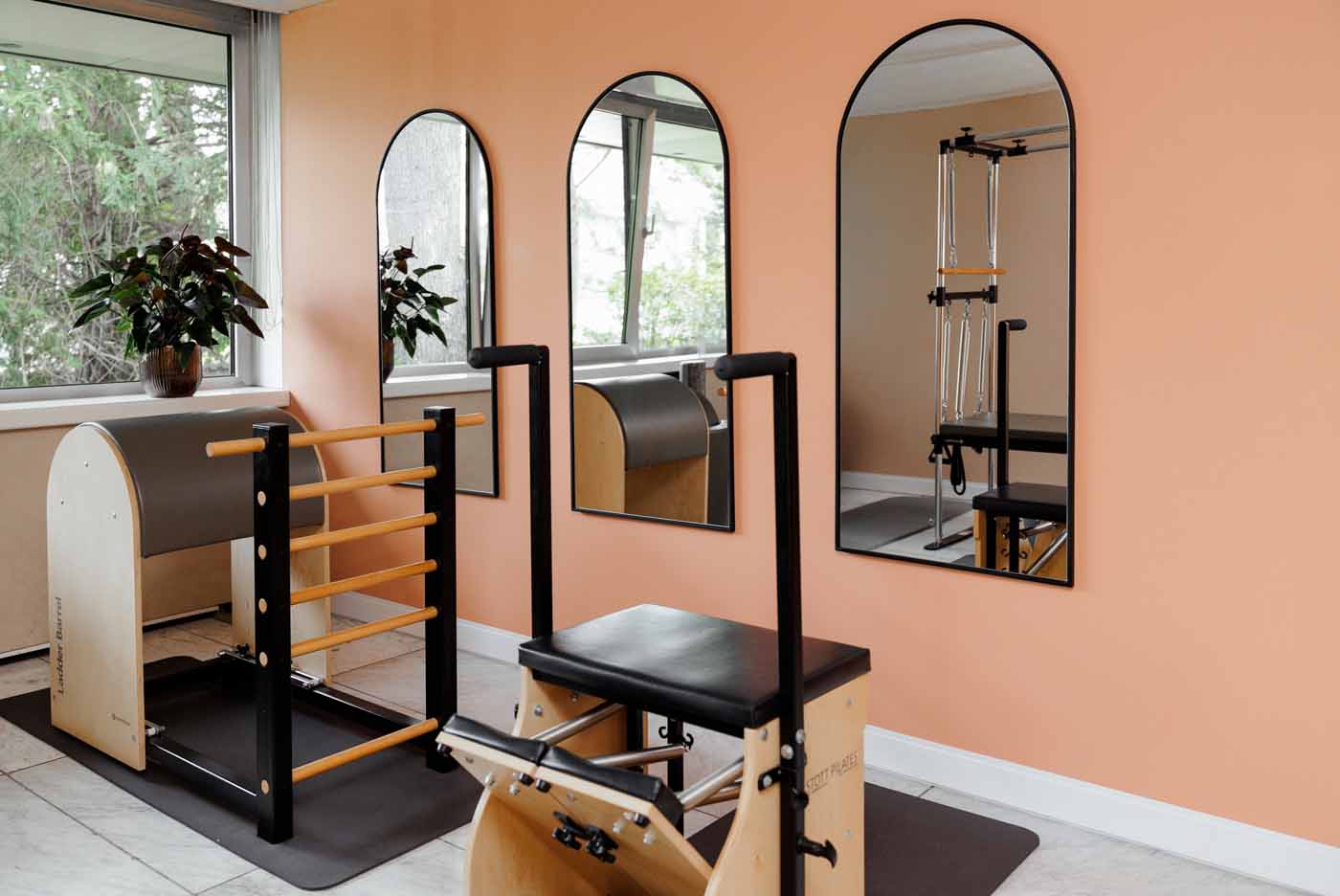 Pilates-Raum Heller Pilates-Raum mit mehreren Holzgeräten, Spiegeln und Gymnastikmatten.