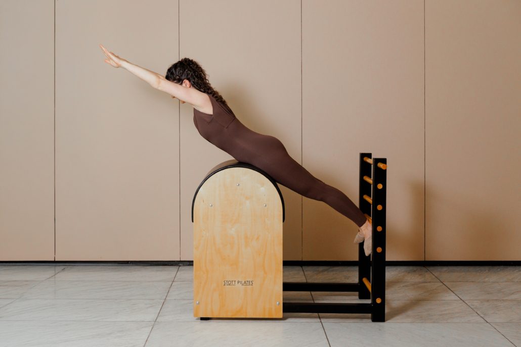 Pilates-Übung auf einem Ladder Barrel Person macht eine Pilates-Übung auf einem Ladder Barrel im modernen Pilates-Studio und trainiert Rücken, Rumpf und Körperspannung.
